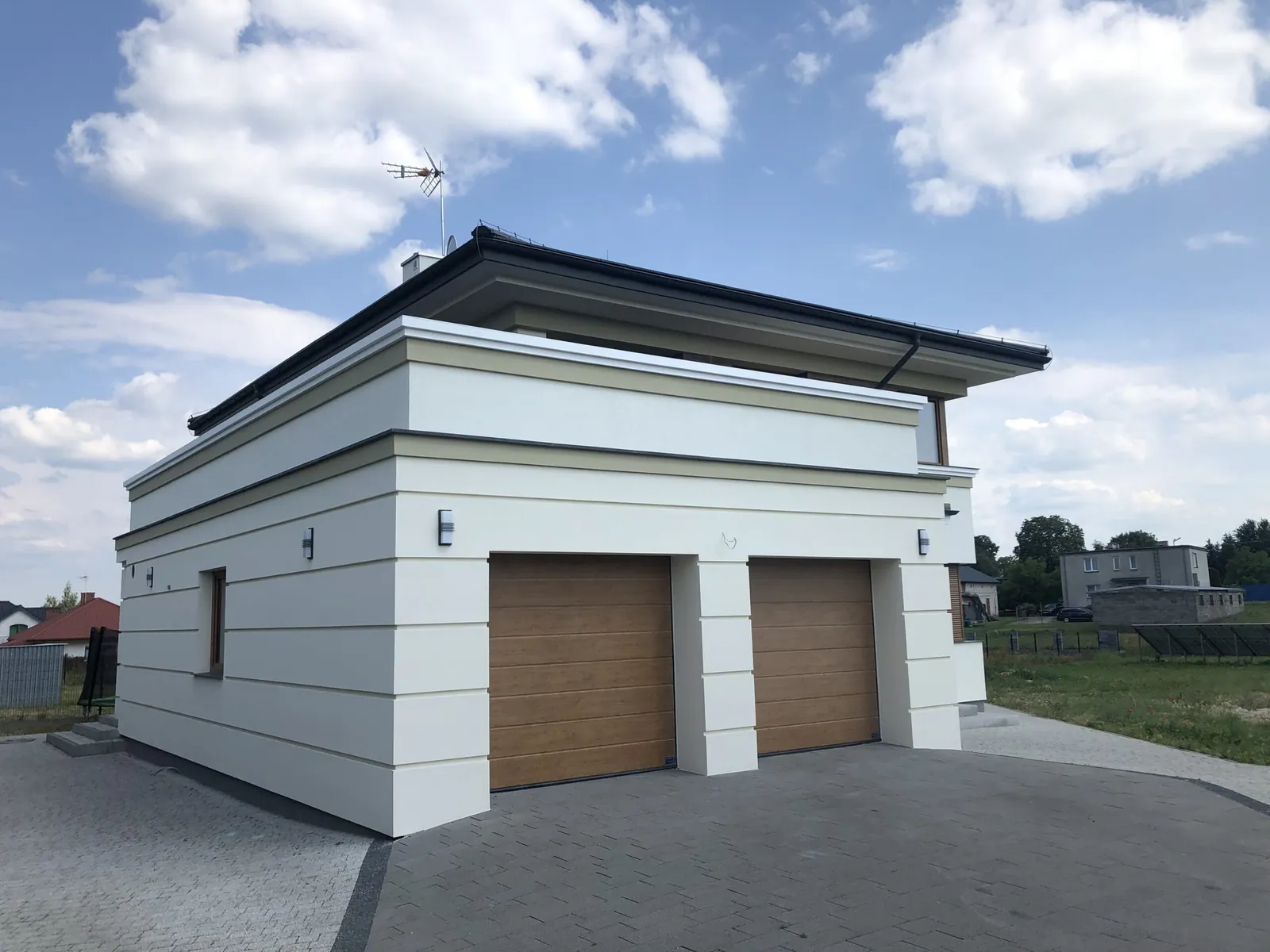 Nowa jasna elewacja budynku z dwustanowiskowym garażem