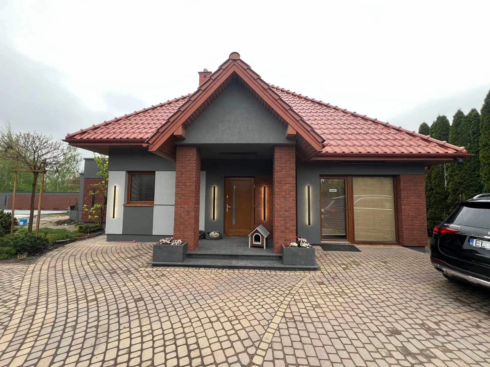Front domu z czerwoną dachówką i nową elewacją