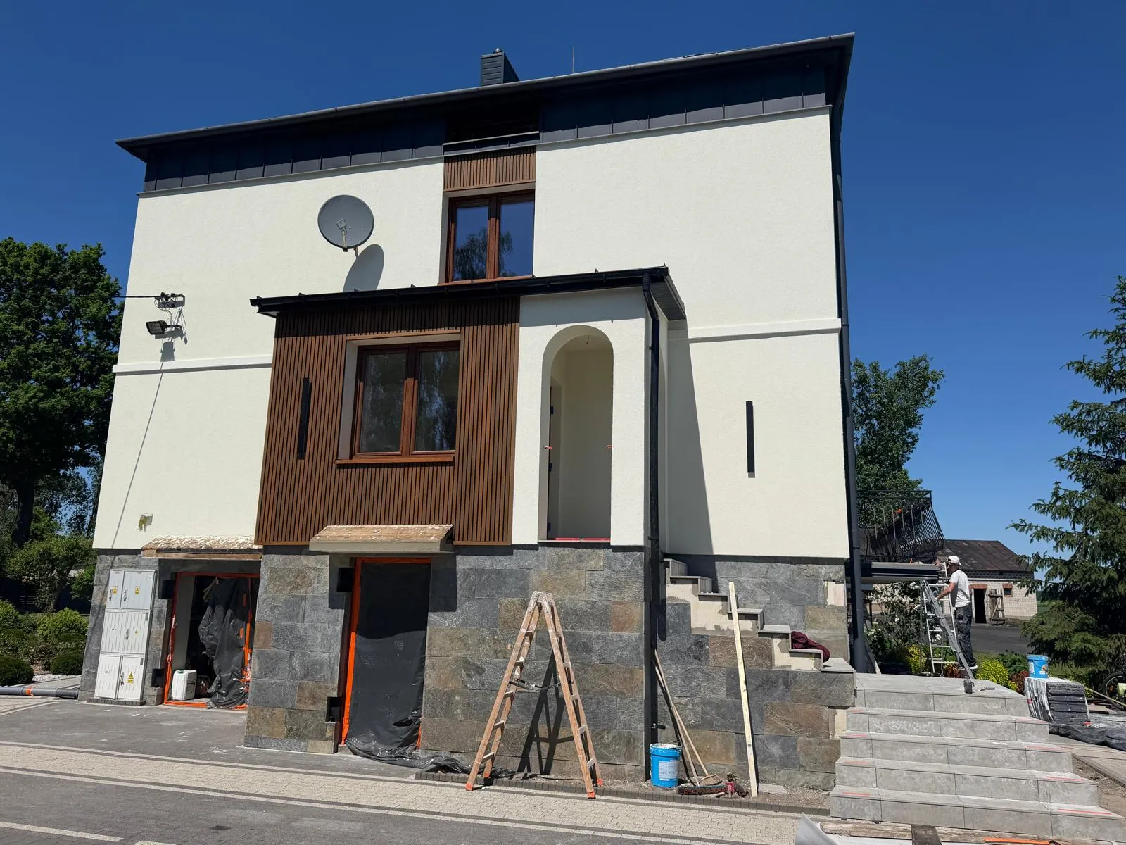 Front domu z łukowym wejściem i okładziną w kolorze drewna