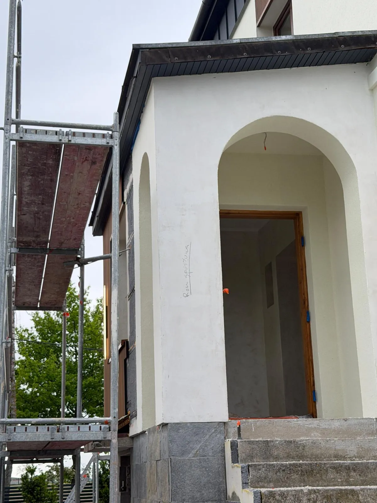Łukowy portal wejścia wykończony tynkiem