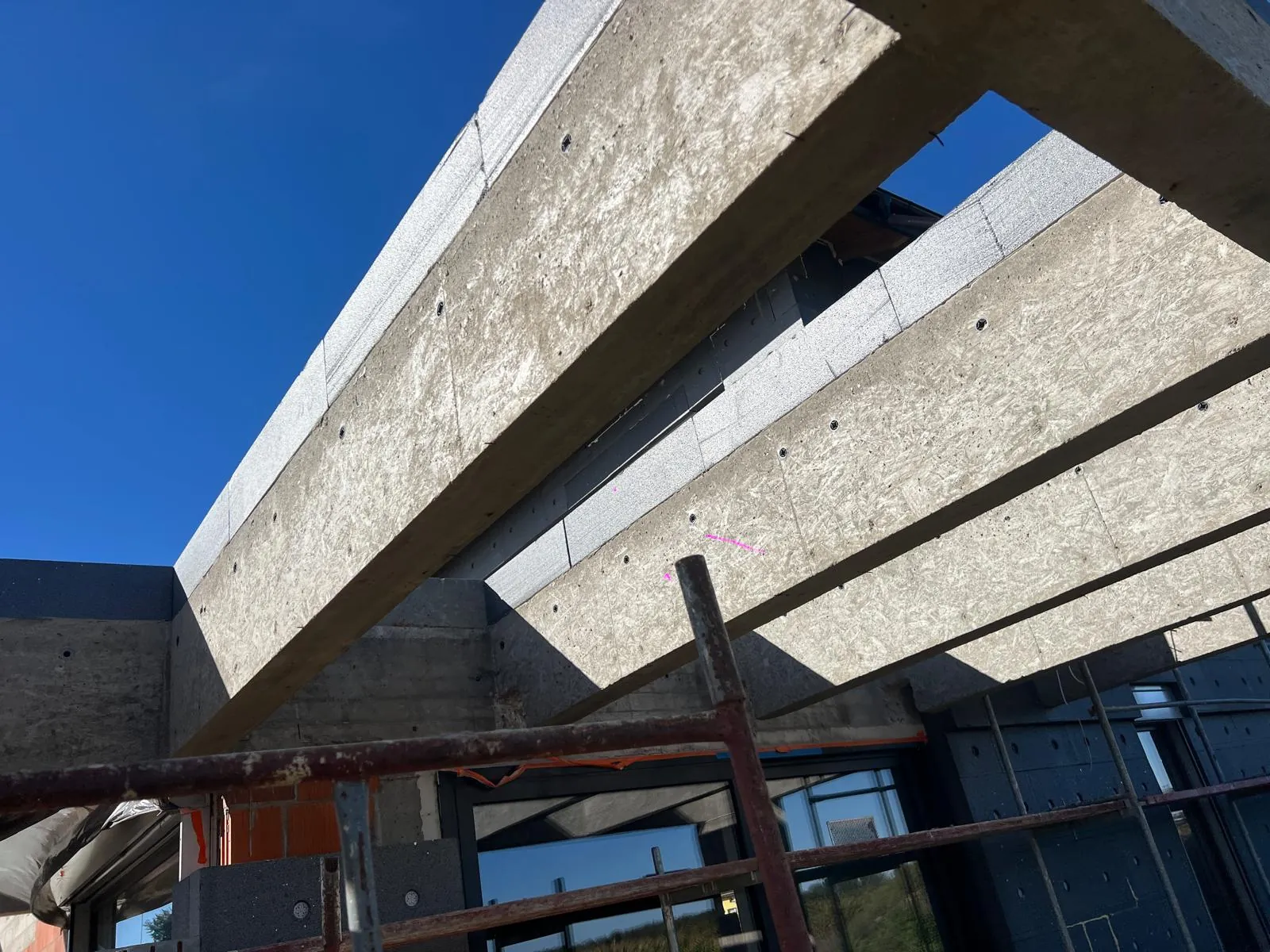 Belki zadaszenia obłożone okładziną w fakturze betonu