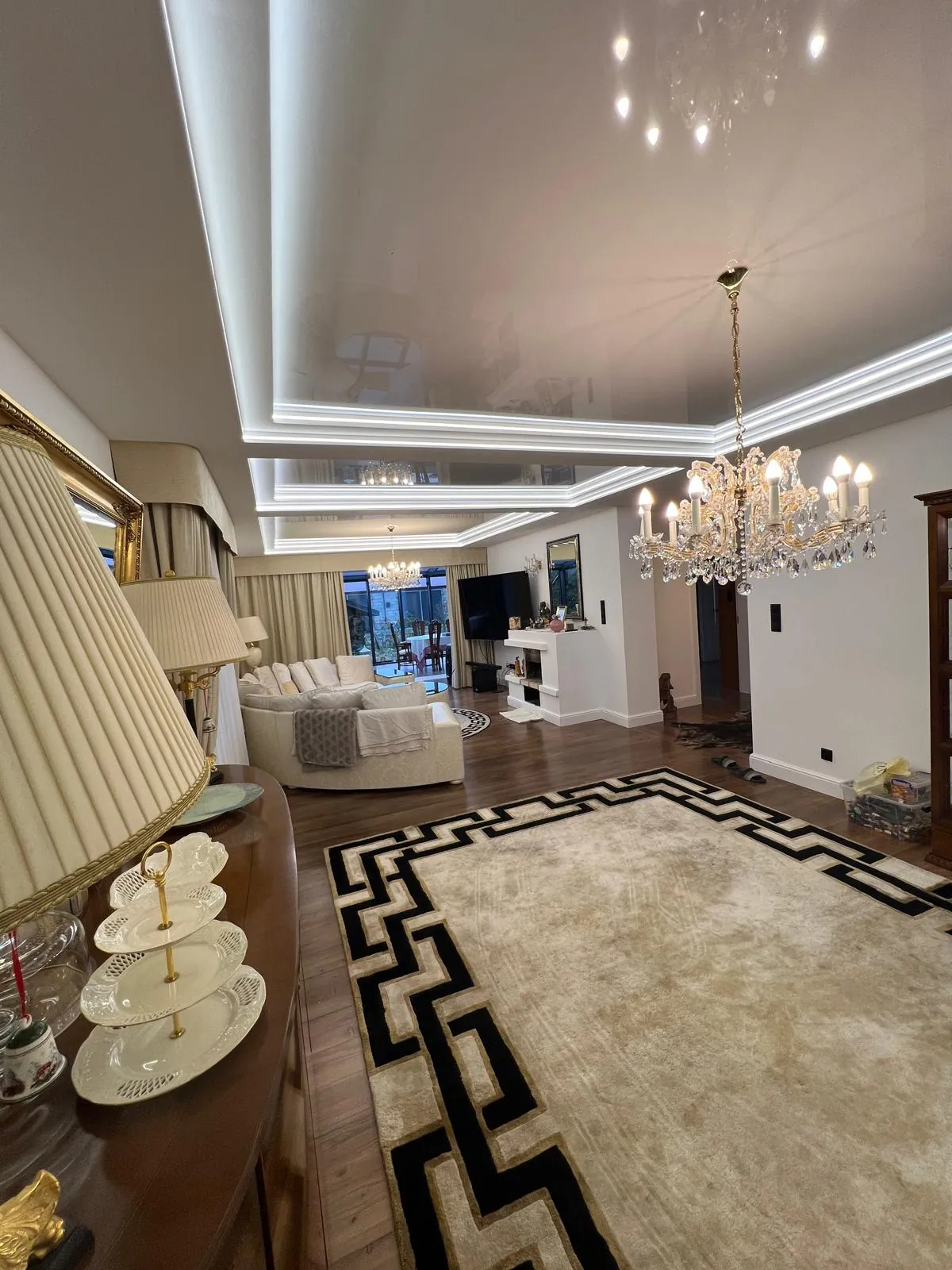 Salon z dywanem w greckie wzory i lustrzaną ścianą