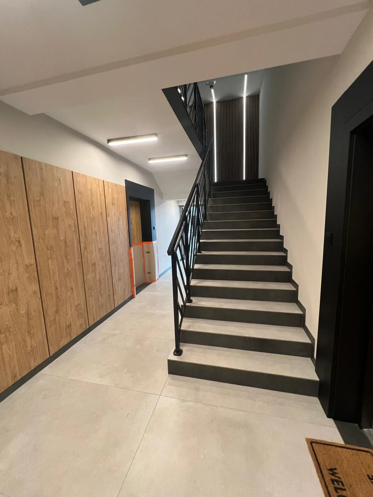 Schody wykończone płytkami z czarną balustradą