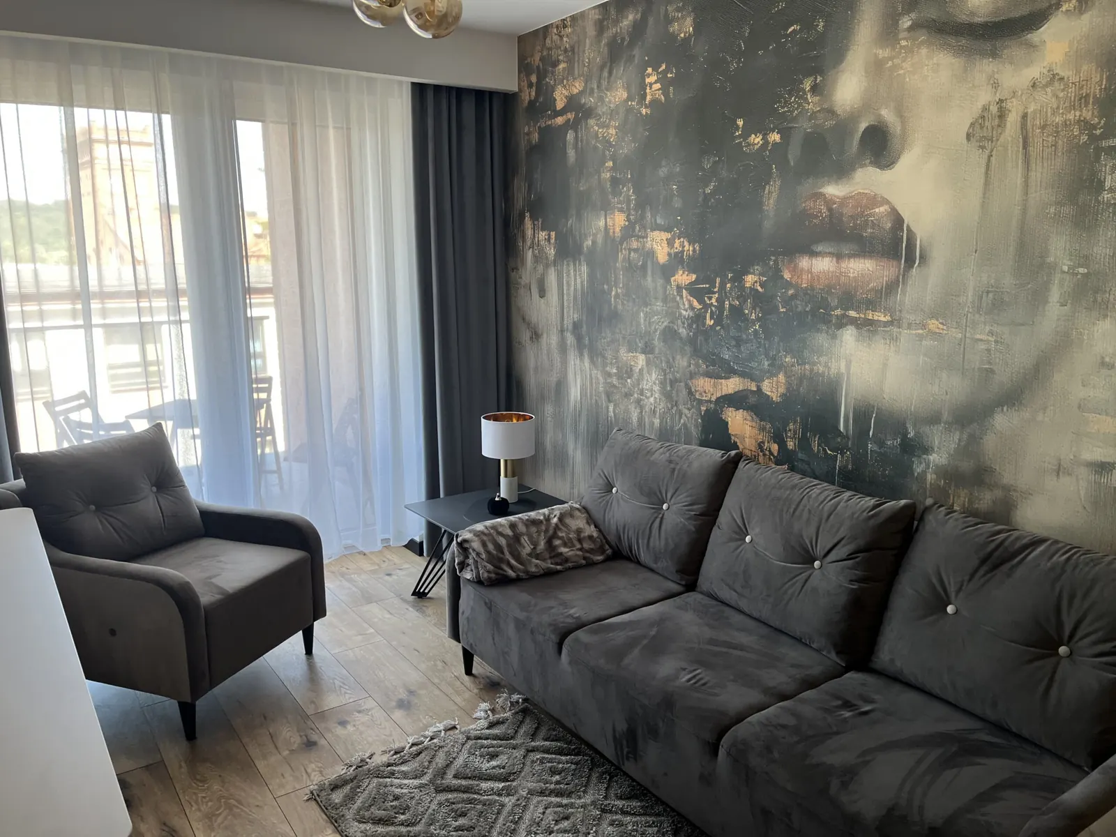 Salon z fototapetą i szarą sofą