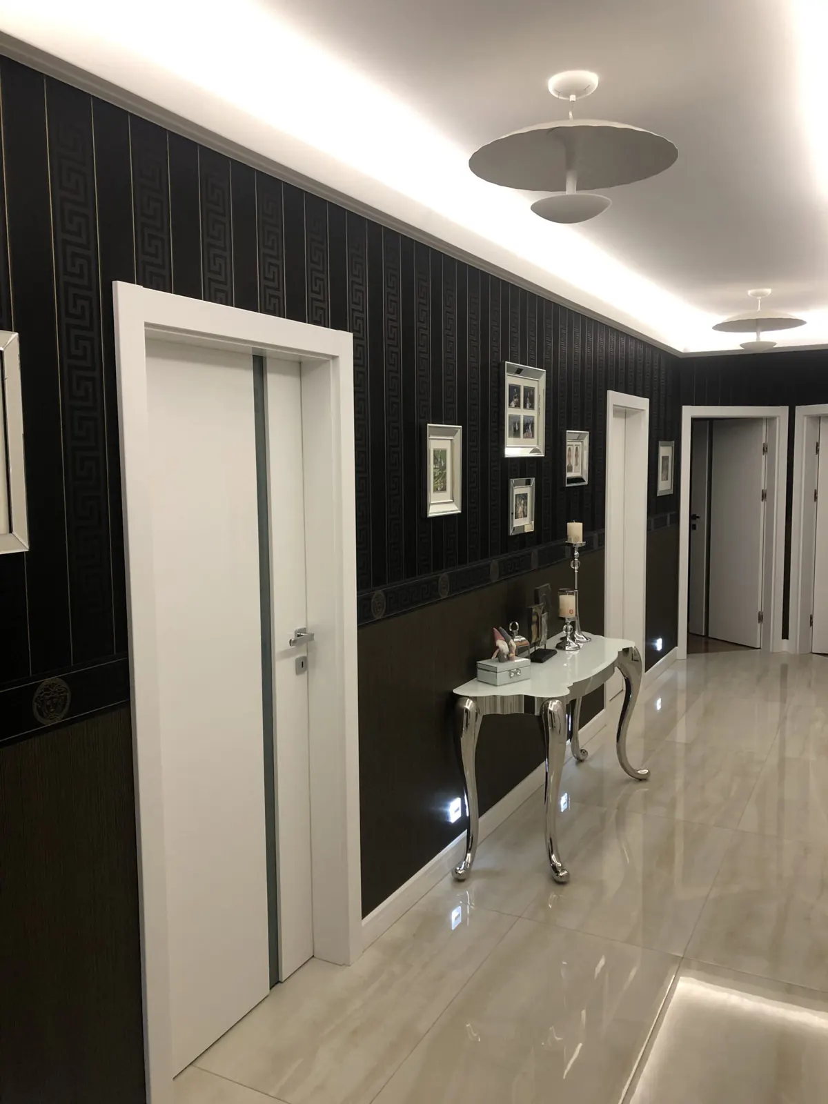 Korytarz z czarnymi drzwiami i konsolą