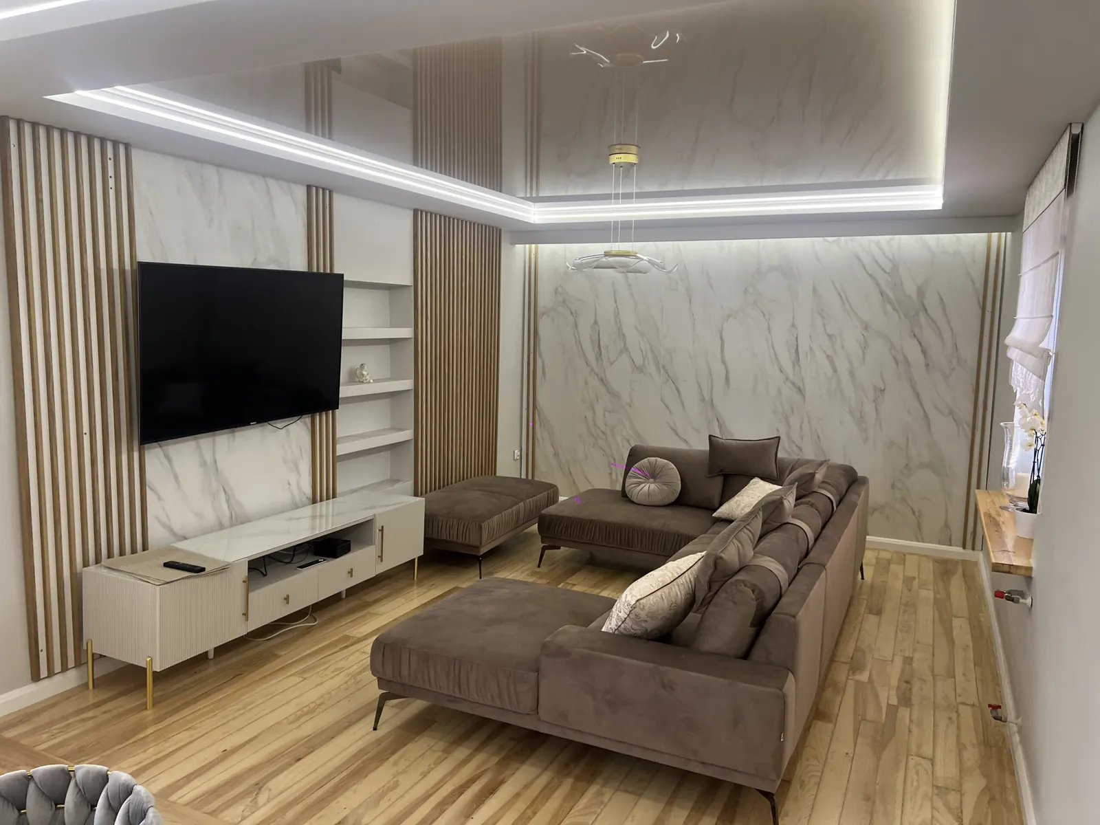 Salon z lamelami i ścianą TV w marmurze